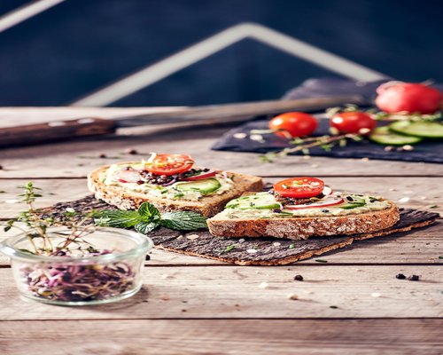 Fresh vegetables and whole grain bread on a wooden table