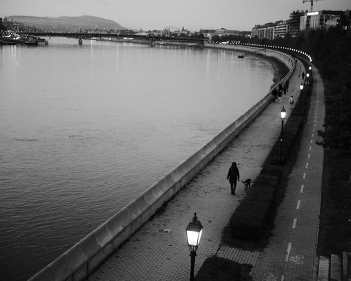Man walking along the Danube river at sunset
